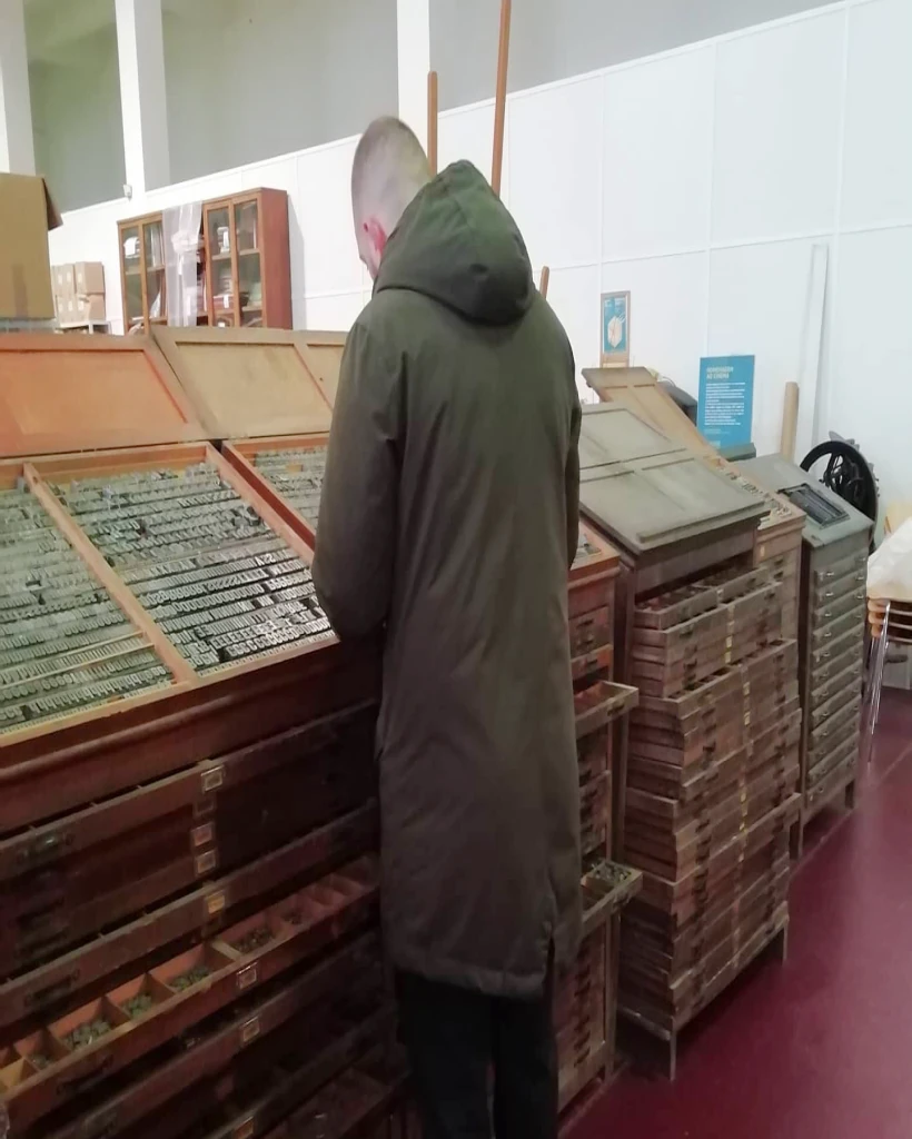 Visitante junto das caixas de tipos móveis do Museu